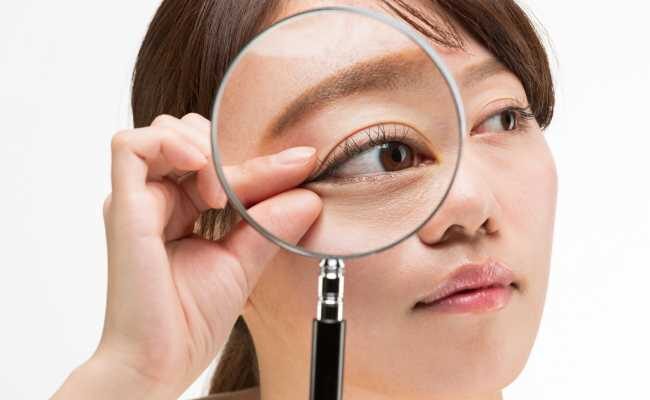 目尻をつまむ女性のイメージ